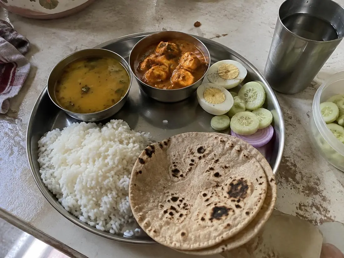 A balanced Indian home-cooked meal with rice, roti, dal, paneer, egg and salad